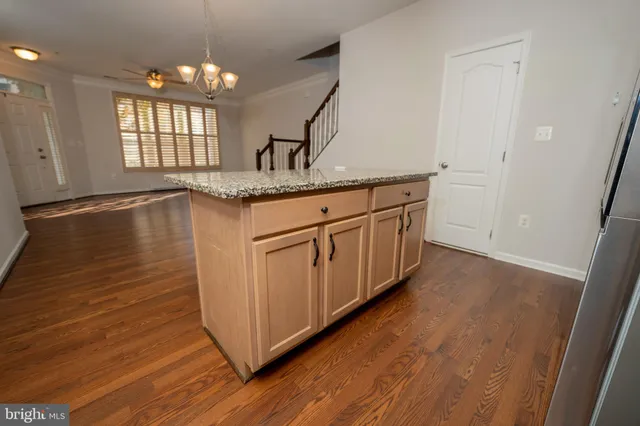 a kitchen with granite countertop white cabinets and wooden floor