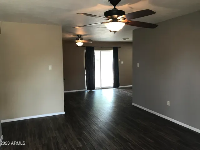 a view of a livingroom with a fan wooden floor and chandelier