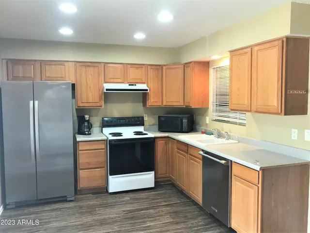 a kitchen with stainless steel appliances granite countertop a refrigerator a sink and a stove