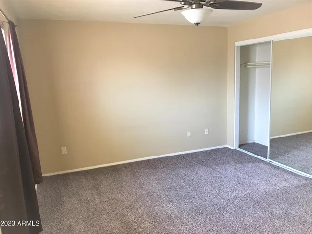 an empty room with a chandelier fan