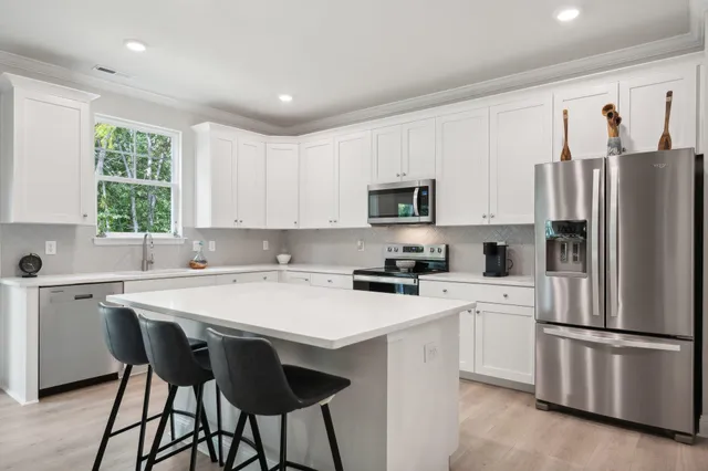 a kitchen with white cabinets and white stainless steel appliances