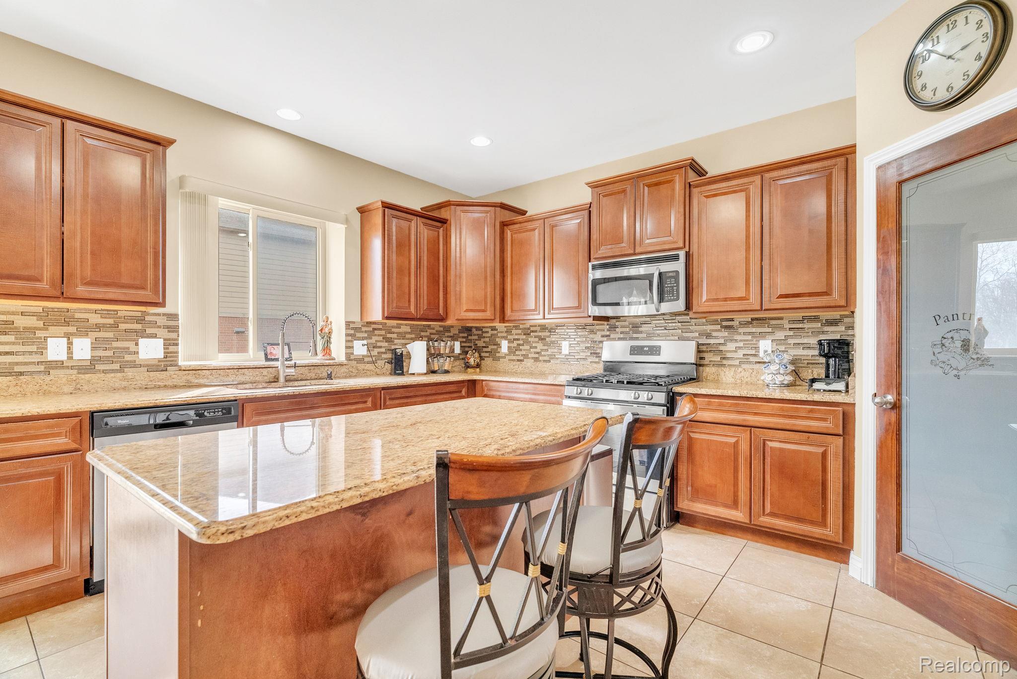 4122 Hawks Nest Road Utica, MI 48317 - Photo 29 of 74 Kitchen featuring light tile patterned floors, wood finish cabinetry, light stone counters, stainless steel appliances, and recessed lighting