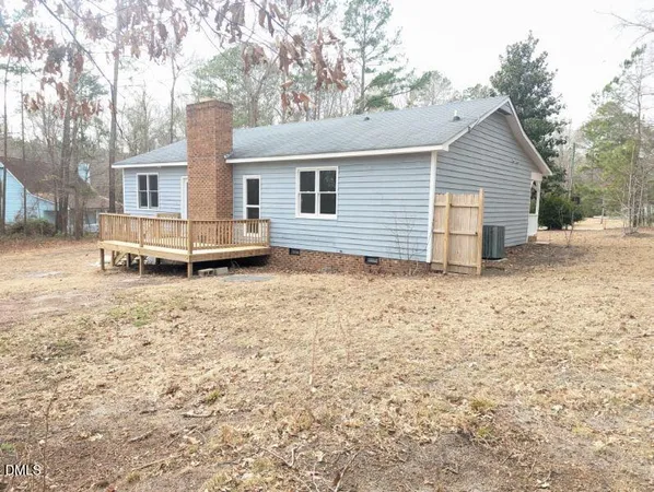 a view of a house with a yard and large tree