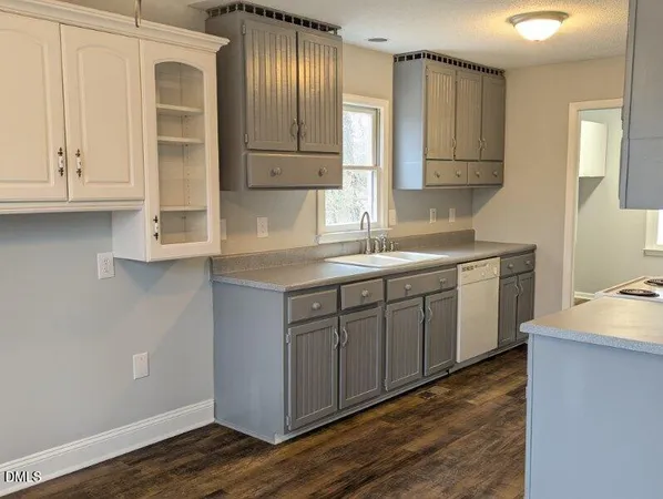 a kitchen with a sink cabinets and wooden floor