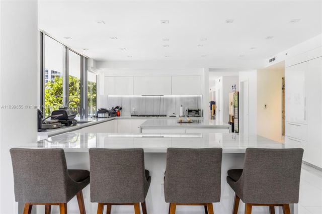 a kitchen with stainless steel appliances a dining table and chairs