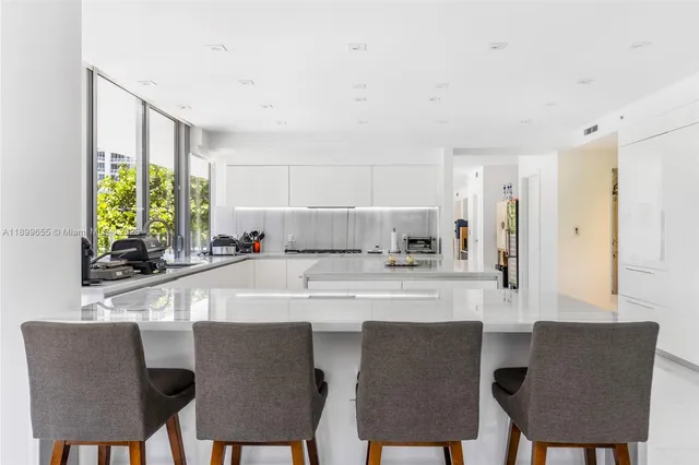 a kitchen with stainless steel appliances a dining table and chairs