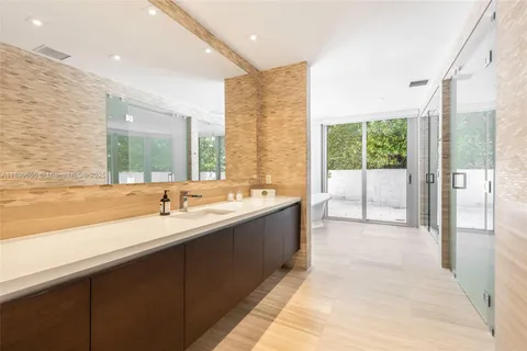 a bathroom with a tub sink and large window