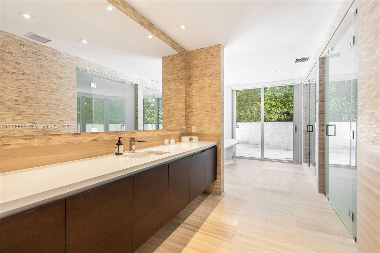 1 Collins Avenue, Unit 207 Miami Beach, FL 33139 - Photo 33 of 44 a large bathroom with a tub sink and mirror