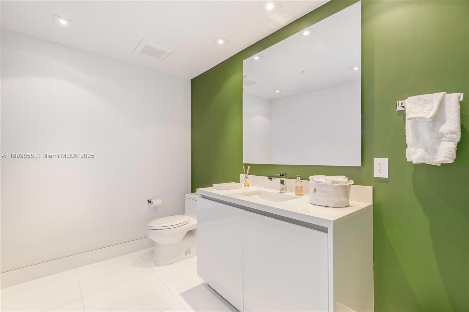 1 Collins Avenue, Unit 207 Miami Beach, FL 33139 - Photo 43 of 44 a bathroom with a sink toilet and mirror