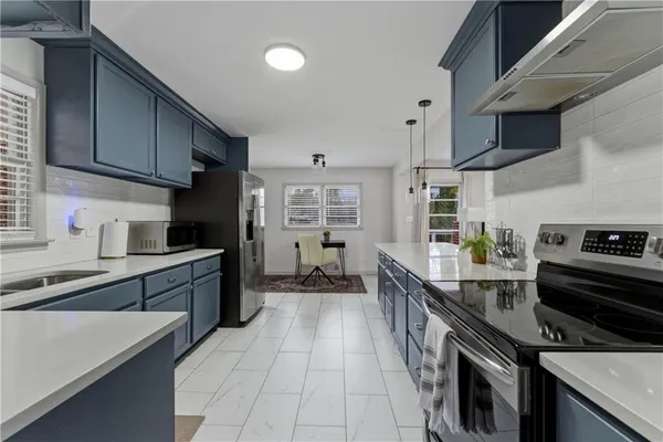 a kitchen with stainless steel appliances a sink stove and cabinets
