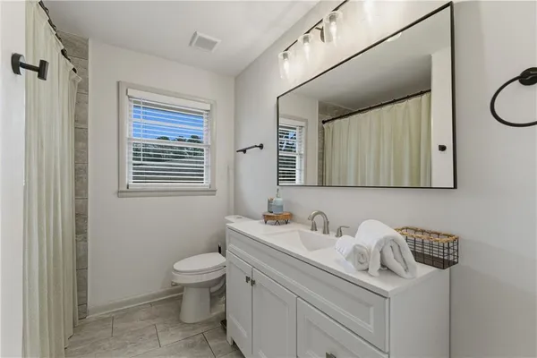 a bathroom with a sink a toilet and a mirror