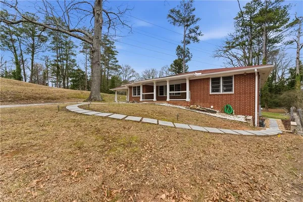 a backyard of a house with wooden fence and large trees