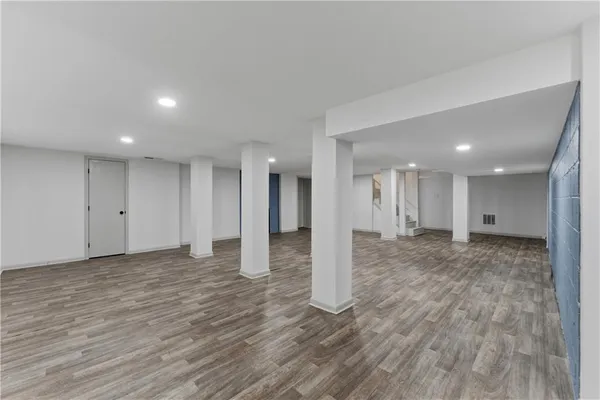 a view of a big room with wooden floor and windows