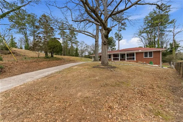 a front view of a house with a yard and trees