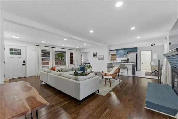 a living room with furniture and a wooden floor