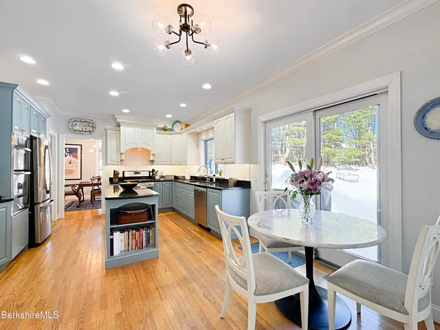 a view of a dining room and livingroom with furniture wooden floor a chandelier
