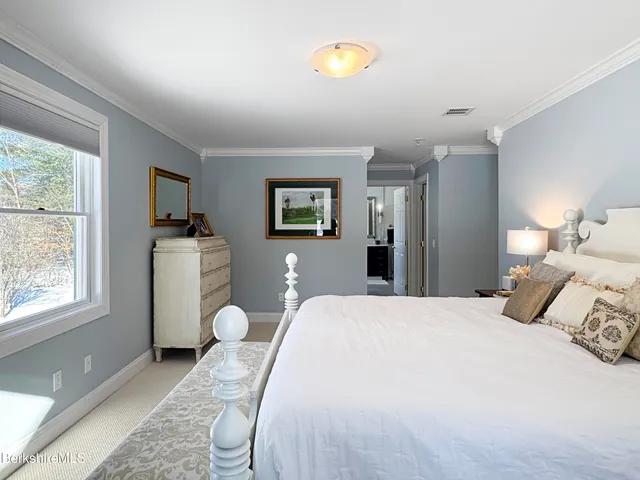 a bedroom with a bed and a large window