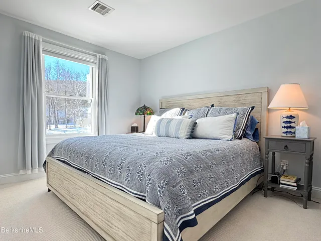 a bed sitting in a bedroom next to a window