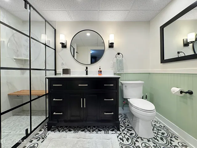 a bathroom with a toilet a sink and a mirror