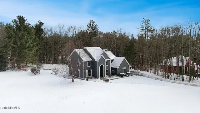 a view of a house with a yard covered in snow