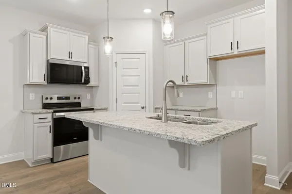 a kitchen with stainless steel appliances granite countertop a sink refrigerator and microwave