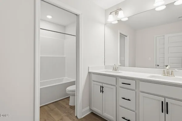 a bathroom with a double vanity sink toilet and shower
