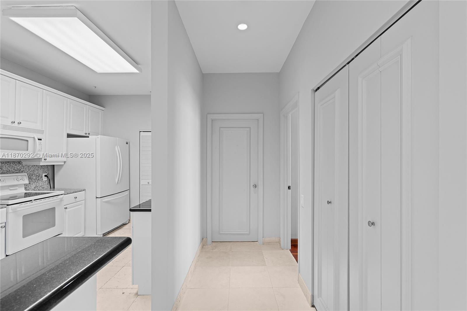 888 Brickell Key Drive, Unit 408 Miami, FL 33131 - Photo 20 of 55 a view of a kitchen with white cabinets and refrigerator