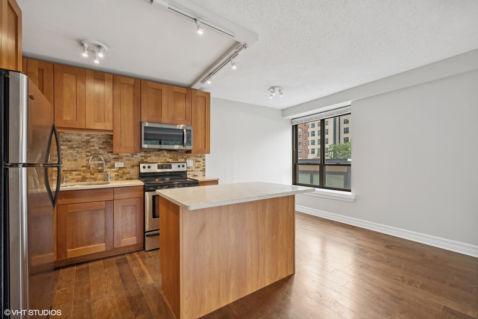 2930 North Sheridan Road, Unit 301 Chicago, IL 60657 - Photo 2 of 20 a kitchen with a refrigerator a stove top oven a sink and a potted plant