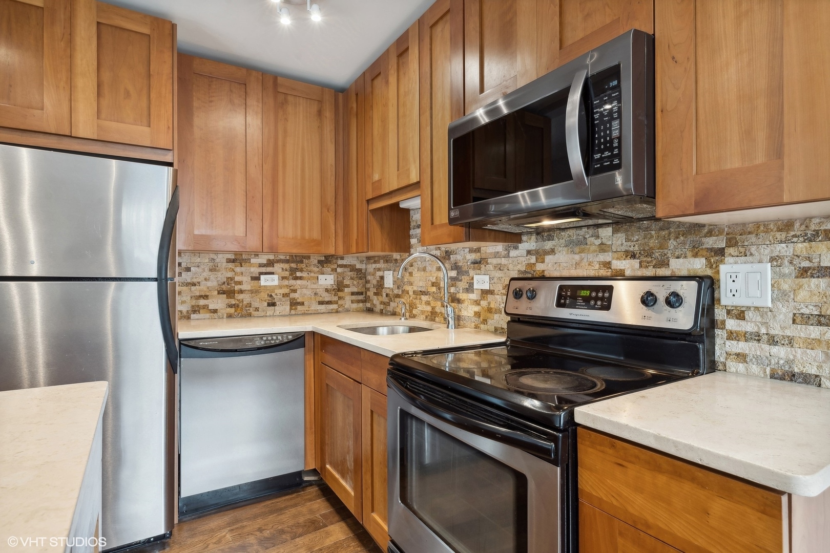 2930 North Sheridan Road, Unit 301 Chicago, IL 60657 - Photo 4 of 20 a kitchen with stainless steel appliances granite countertop a stove microwave sink and refrigerator