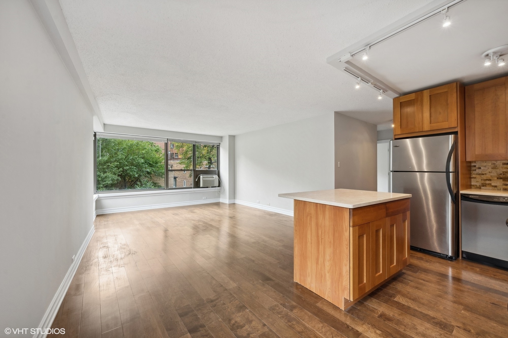 2930 North Sheridan Road, Unit 301 Chicago, IL 60657 - Photo 5 of 20 an empty room with wooden floor and a window