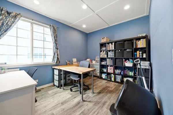 a view of a workspace with furniture and a bookshelf
