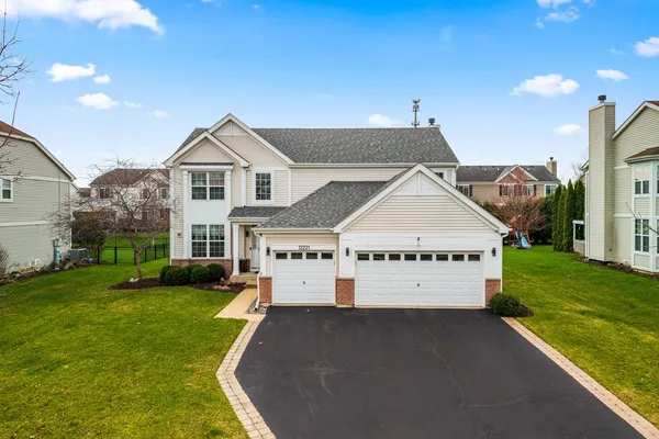 a large house with a big yard and more large tree