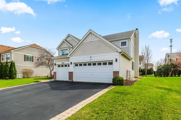 a view of a white house next to a yard and large trees