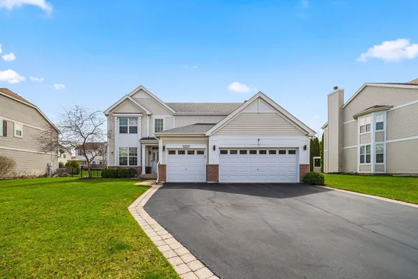 a view of a house with a big yard and large trees
