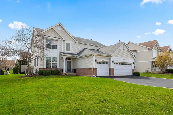 a view of a white house next to a yard and large trees