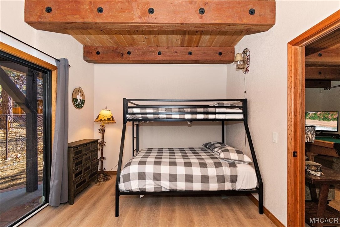 1584 Wolf Road Big Bear City, CA 92314 - Photo 8 of 33 a bedroom with a bed and wooden floor