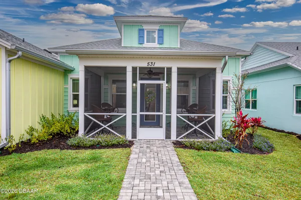 a front view of a house with a yard and potted plants