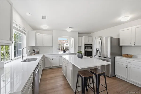 a large kitchen with a table chairs refrigerator and cabinets