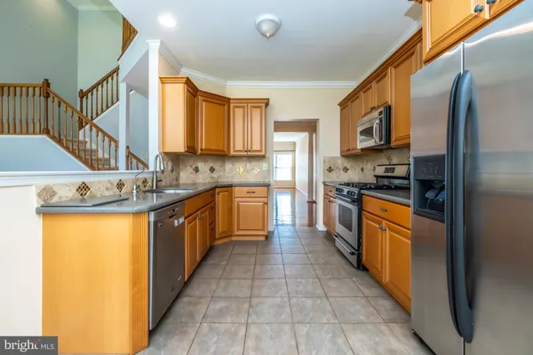 a large kitchen with stainless steel appliances granite countertop a stove a sink dishwasher and a refrigerator