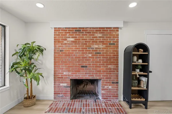 a living room with a potted plant and a fireplace