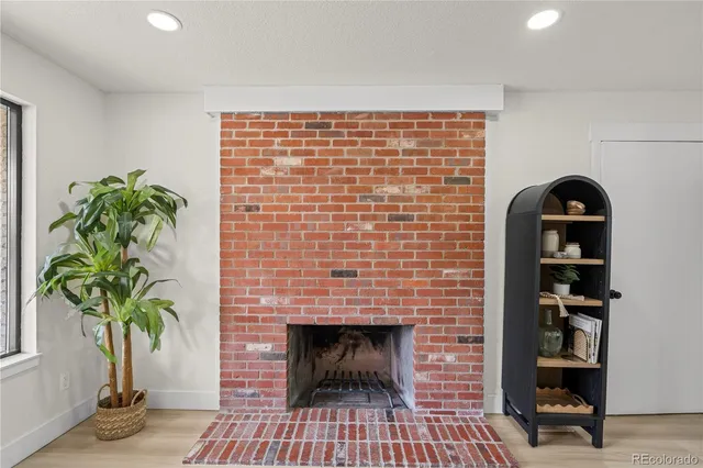 a living room with a potted plant and a fireplace