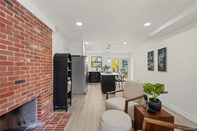 a living room with furniture a potted plant and a fireplace