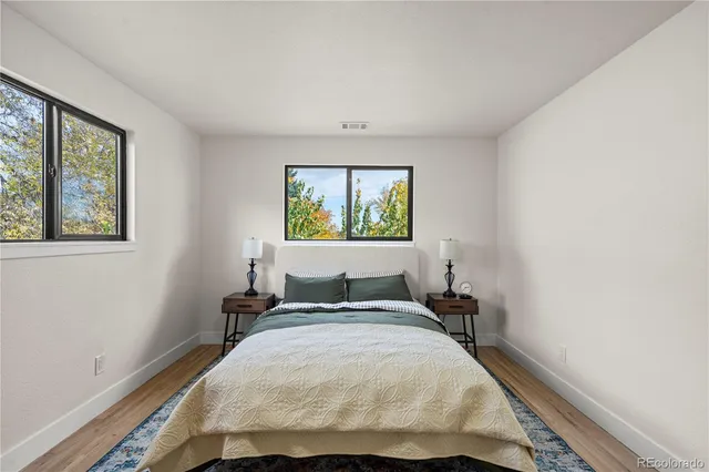 a bedroom with a bed and painting on the wall
