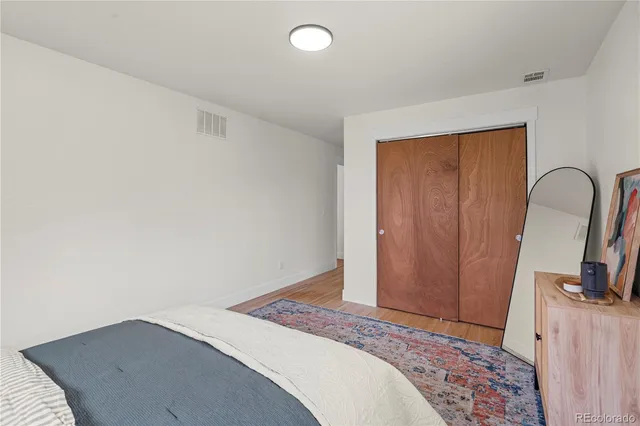 a bedroom with a bed and a mirror on the dresser