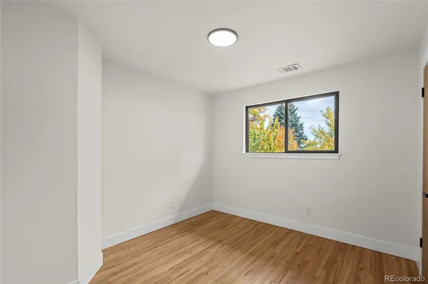 a view of empty room with wooden floor