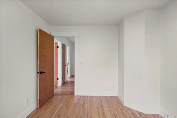 a view of a room with wooden floor and a hallway