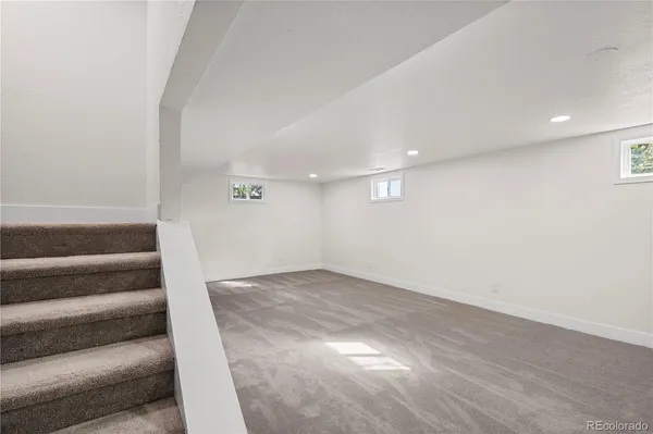 a view of an empty room with wooden floor and windows