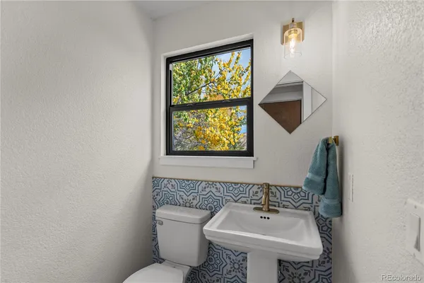 a bathroom with a toilet a sink and a mirror