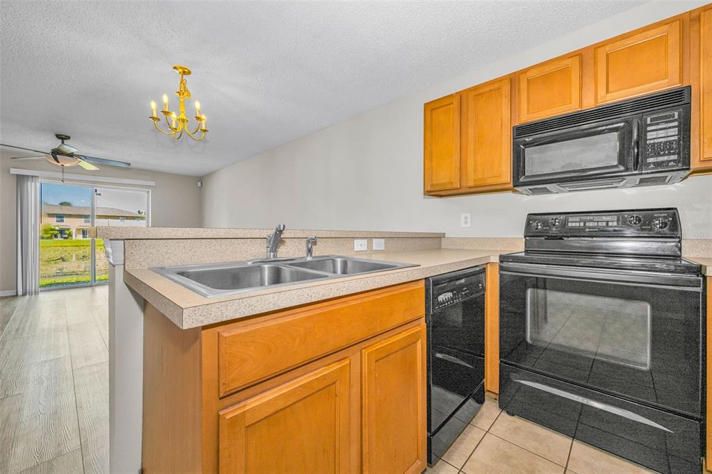 8015 Savannah Sunset Lane Tampa, FL 33615 - Photo 11 of 35 a kitchen with a stove a sink and a microwave