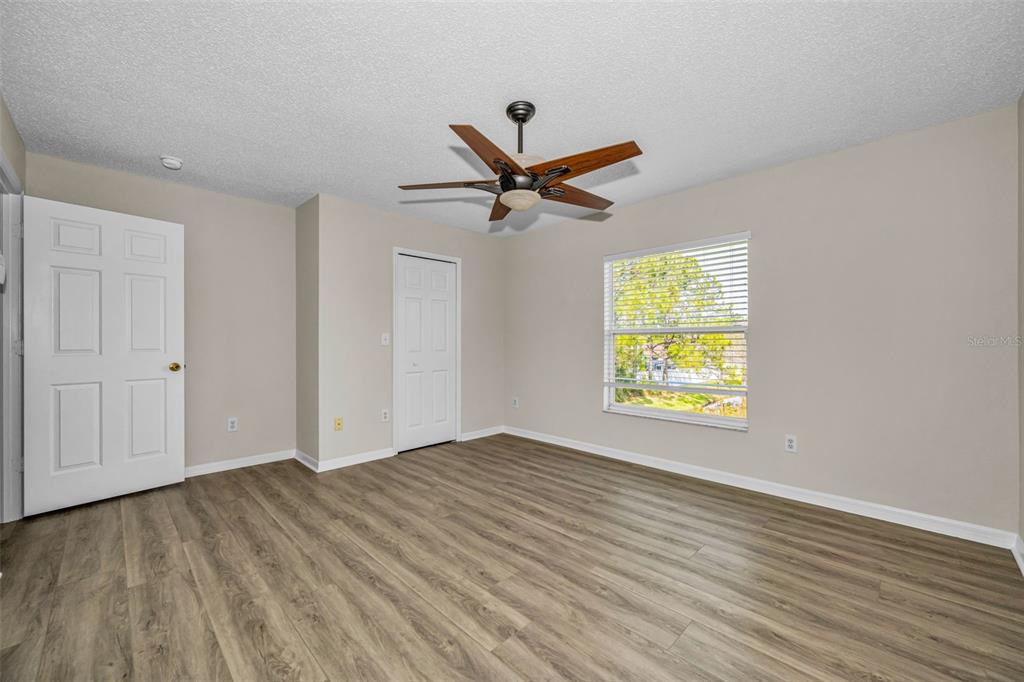 8015 Savannah Sunset Lane Tampa, FL 33615 - Photo 18 of 35 an empty room with windows and a ceiling fan